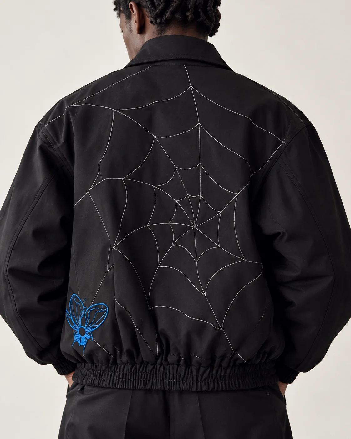 Back view of Side B with the large web stitch graphic and blue embroidered detail